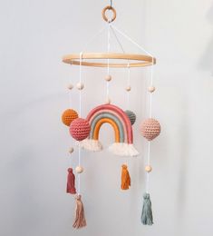 a crocheted rainbow mobile hanging from a wall