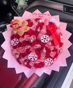 a bouquet of roses in the shape of a heart with a teddy bear on it