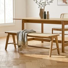 a wooden table with two chairs and a bench in front of it on a hard wood floor