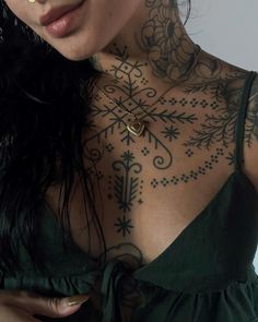 a woman with tattoos on her chest wearing a green dress