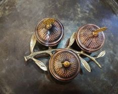 three glass dishes sitting on top of a metal tray covered in gold leaf designs and birds