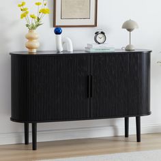 a black sideboard with two vases on it and a clock in the corner