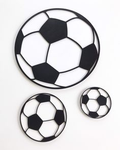 three black and white soccer balls cut out from paper on a white surface with space for text