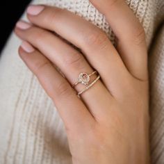 a woman's hand wearing a gold ring with diamonds on the middle, and a diamond set in the middle