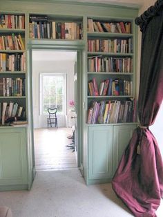 an open door leading to a room with bookshelves full of books in it