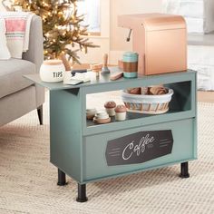 a small coffee shop table in front of a couch with a christmas tree behind it