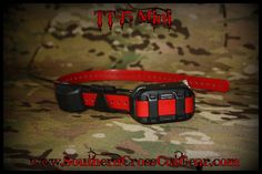 a red and black dog collar on a camouflage background