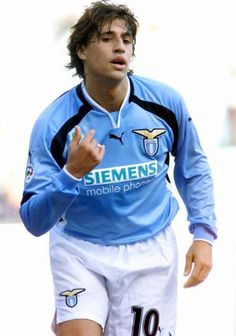 a man in blue shirt and white shorts playing soccer