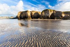 the sandy beach is lined with rock formations