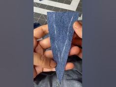 someone is holding up a piece of denim fabric to show it's stitching