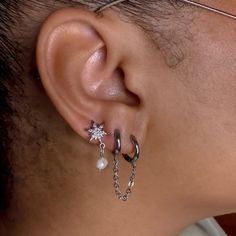 a person wearing ear piercings with chains and pearls