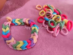 several different colored bracelets sitting on top of a pink blanket