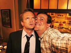 two men are posing for the camera with their heads close to each other in a kitchen