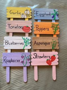 four popsicles with different types of vegetables painted on them and labeled in the words