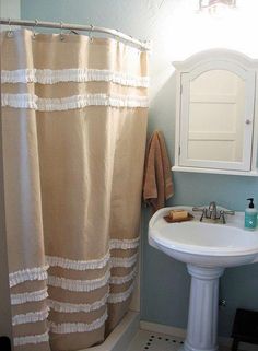 a bathroom with a sink, mirror and shower curtain