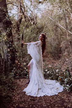 a woman in a white dress holding an arrow