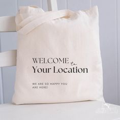 a tote bag sitting on top of a white chair with the words, welcome to your location we are so happy you are here