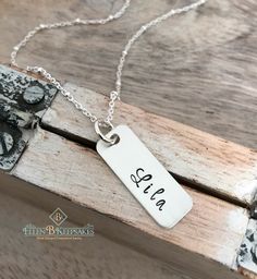 "Every mother loves to keep the names of her kids close to her heart. Give her this hand stamped sterling silver kids name necklace and she'll wear it for years to come. The perfect piece of mommy jewelry or a thoughtful gift for grandma! This personalized name tag necklace is made of: *Sterling silver tag, hand stamped with UP TO 8 LETTERS *Sterling silver jump ring *Sterling silver 18\" chain Take a look at some of my other personalized mom jewelry here! https://www.etsy.com/shop/EllenBKeepsak Personalized Mom Jewelry, Name Tag Necklace, Mom Jewelry Personalized, Necklace With Kids Names, Kids Close, Necklace With Name, Silver Name Necklace, Mommy Jewelry, Sterling Silver Name Necklace