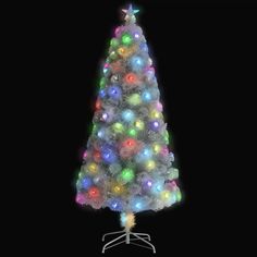 a white christmas tree with multi - colored lights on it's base and a black background