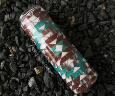 a can sitting on top of some rocks and gravel next to it's wrapper