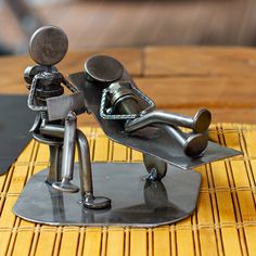 a metal figurine sitting on top of a wooden table