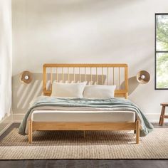 a bed sitting in a bedroom on top of a wooden floor next to a window