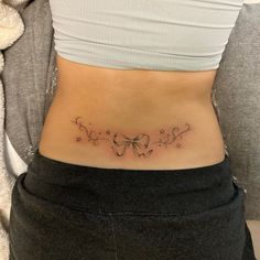 a woman's stomach with a butterfly tattoo on her lower side ribcage