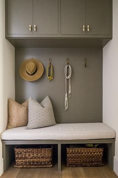 a bench with two baskets and hats on the wall above it, along with other items