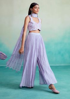 Introducing the luminova crop-top & sharara set in lavender! This exquisite ensemble is crafted from soft chanderi fabric, ensuring both comfort and elegance. The crop-top features hand-embroidered motifs inspired by kutch's rich heritage, blending tradition with a modern design. The set includes a micro-pleated sharara and a mirror work dupatta with handmade hangings, adding a delightful sparkle to your look. Anarkali Sets In Lavender For Diwali, Festive Anarkali Set In Lavender, Lavender Anarkali Set For Festive Occasions, Festive Lavender Anarkali Sets, Cotton Sets With Sheer Dupatta For Summer, Lavender Saree Sets With Dupatta, Summer Cotton Sets With Sheer Dupatta, Lavender Anarkali Set For Diwali, Designer Lavender Sharara For Diwali