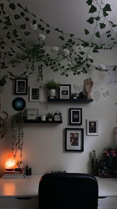 a living room filled with lots of plants and pictures hanging on the wall next to a chair