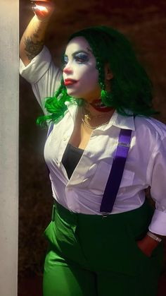 a woman with green hair and makeup is dressed as the person in the joker movie