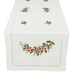 a white table cloth with holly and berries on the border is displayed in front of a white background