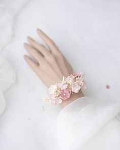 a close up of a hand wearing a ring with flowers on it