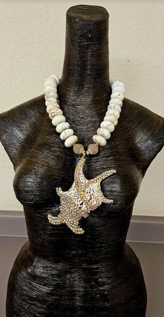 Here's another piece from my private collection, albeit it new and unworn. I bejeweled an exotic shell with gold aurora borealis rhinestones and attached it to an understated, yet rich and posh off white magnesite rondelle necklace. This piece adjusts from 21-25" and closes with gold tone hardware, a lobster claw clasp and a 4" extender chain. A fancy beaded dangle is suspended off the extender chain which adds interest and drama to the back. The single strand necklace consists of magnesite rond Rondelle Necklace, Fancy Beads, Chest Piece, Gold Rhinestone, Shell Pendant, Beaded Dangles, White Beads, Strand Necklace, Aurora Borealis