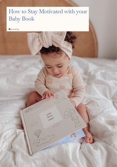 a baby sitting on a bed holding a book with the title how to stay motivitated with your baby book