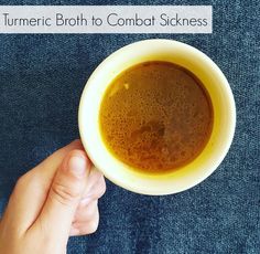 a person holding a cup of coffee with the words tumeric broth to combat sickness