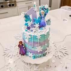 a frozen princess birthday cake on a table with snowflakes and stars around it