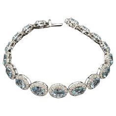 Introducing the epitome of elegance, the 15.58ct Oval Aquamarine and Diamond Halo Bracelet, a dazzling masterpiece in 18kt White Gold. This bracelet features enchanting oval-shaped Aquamarines with a total weight of 12.41ct, radiating a captivating azure hue reminiscent of tranquil waters. The Aquamarines are delicately encircled by a halo of brilliant Round Diamonds, totaling 3.17ct and exhibiting a G color and SI2 clarity. Crafted in 18kt White Gold, the setting adds a touch of sophistication Luxury Formal Halo Bracelets, Luxury Turquoise Oval Bracelets, Halo Bracelet, Aqua Marine, Fine Jewels, Diamond Halo, Halo Diamond, Timeless Beauty, Arm Band