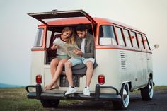 two people sitting in the back of an old vw bus