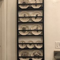 a black shelf with plates on it in a room