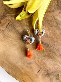 Add a touch of vibrant charm to your look with our Heart-Shaped Talavera Earrings! These stunning earrings feature intricate designs inspired by traditional Talavera pottery, accented with delightful hanging tassels in a rainbow of colors. Perfect for bringing a playful and colorful flair to any outfit. Elevate your style with these unique and eye-catching statement earrings. Gold pleated brass.Charm size: 1 inch.Total length: 2.5 inches. Traditional Heart-shaped Jewelry For Festive Occasions, Traditional Colorful Festival Earrings, Festival Gift Jewelry With Tassels, Colorful Traditional Earrings, Traditional Multicolor Tassel Jewelry, Tassel Earrings As Festival Gifts, Hand Painted Multicolor Heart Earrings As Gift, Traditional Multicolor Adjustable Earrings, Hand Painted Multicolor Heart Earrings For Gift