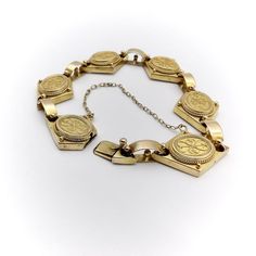 This is part of Chairish’s Fine Jewelry assortment.  A beautiful 14k yellow gold bracelet from the Etruscan Revival period, circa 1880. The bracelet is exquisitely hand-made and is a fine example of cannetille gold work, which is similar to filigree work with fine gold wires that curl around thinly hammered sheets. Cannetille gold work was inspired by embroidery and nature. The repeating curling designs on each segment of the bracelet are harmonious and elegant. The diamond shape of the segment Ceremonial Hallmarked Yellow Gold Bracelet, Hallmarked Yellow Gold Bracelet For Ceremonial Occasions, Antique Yellow Gold Intaglio Jewelry, Antique Hallmarked Gold Bracelet For Ceremonial Occasions, Antique Engraved Yellow Gold Bracelet, Antique Yellow Gold Bracelet For Ceremonial Occasions, Antique Yellow Gold Jubilee Bracelet, Victorian Engraved Gold Bracelet For Ceremonial Occasions, Victorian Gold Hallmarked Bracelet