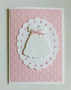 a pink and white card with a dress on it