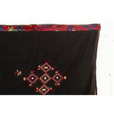 This fabulous antique Kohistani shawl whispers stories of the Mangal people, inhabiting the borderlands of eastern Afghanistan and western Pakistan. This antique shawl was Traditionally worn by women as a head covering during wedding or ceremonies, this piece is a testament to the Mangal's artistry and cultural heritage. Hand-crafted from heavy black cotton, the shawl is adorned with intricate silk embroidery. Geometric and floral motifs in vibrant colors like red, green and yellow dance across Ceremonial Shawl With Embroidered Border And Traditional Drape, Ceremonial Shawl With Embroidered Border, Traditional Dupatta Shawl With Border, Traditional Dupatta With Border In Shawl Shape, Traditional Shawl Shaped Dupatta With Border, Traditional Shawl-style Dupatta With Border, Bohemian Ceremonial Shawl With Motifs, Bohemian Shawl With Motifs For Ceremonial Use, Bohemian Shawl With Motifs For Ceremonial Occasions