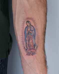 a man's arm with a tattoo of the virgin mary and jesus on it