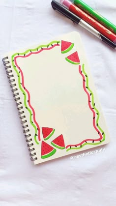 a notepad with watermelon designs on it next to some markers and pencils