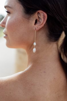 a close up of a person wearing some kind of earring with pearls on it