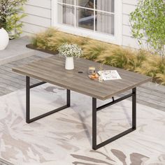 a coffee table sitting on top of a rug in front of a house next to a window