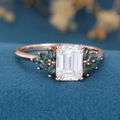 an emerald colored diamond ring with leaves on it