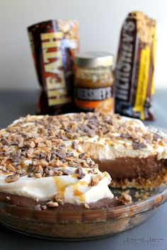 a chocolate pie with white frosting and nuts on top, sitting on a table